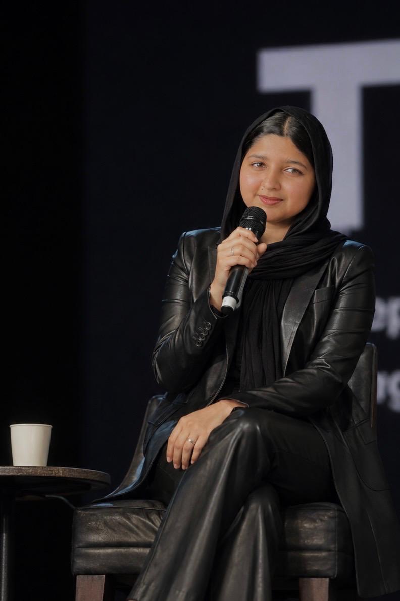 Fathima Shifna, digital marketing expert, speaking on stage with microphone at a panel event